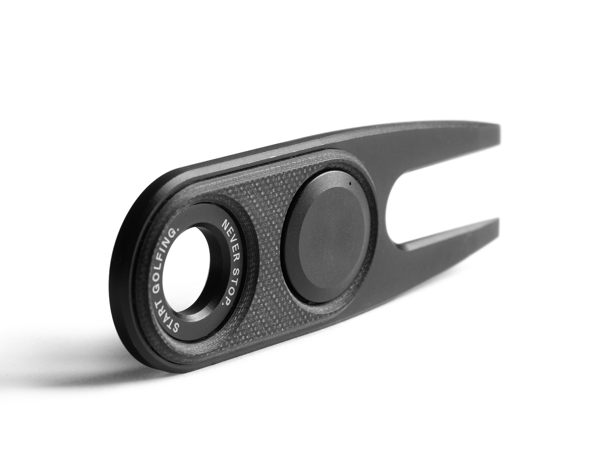 Black golf divot tool with 'Never Stop Golfing' text on a white background