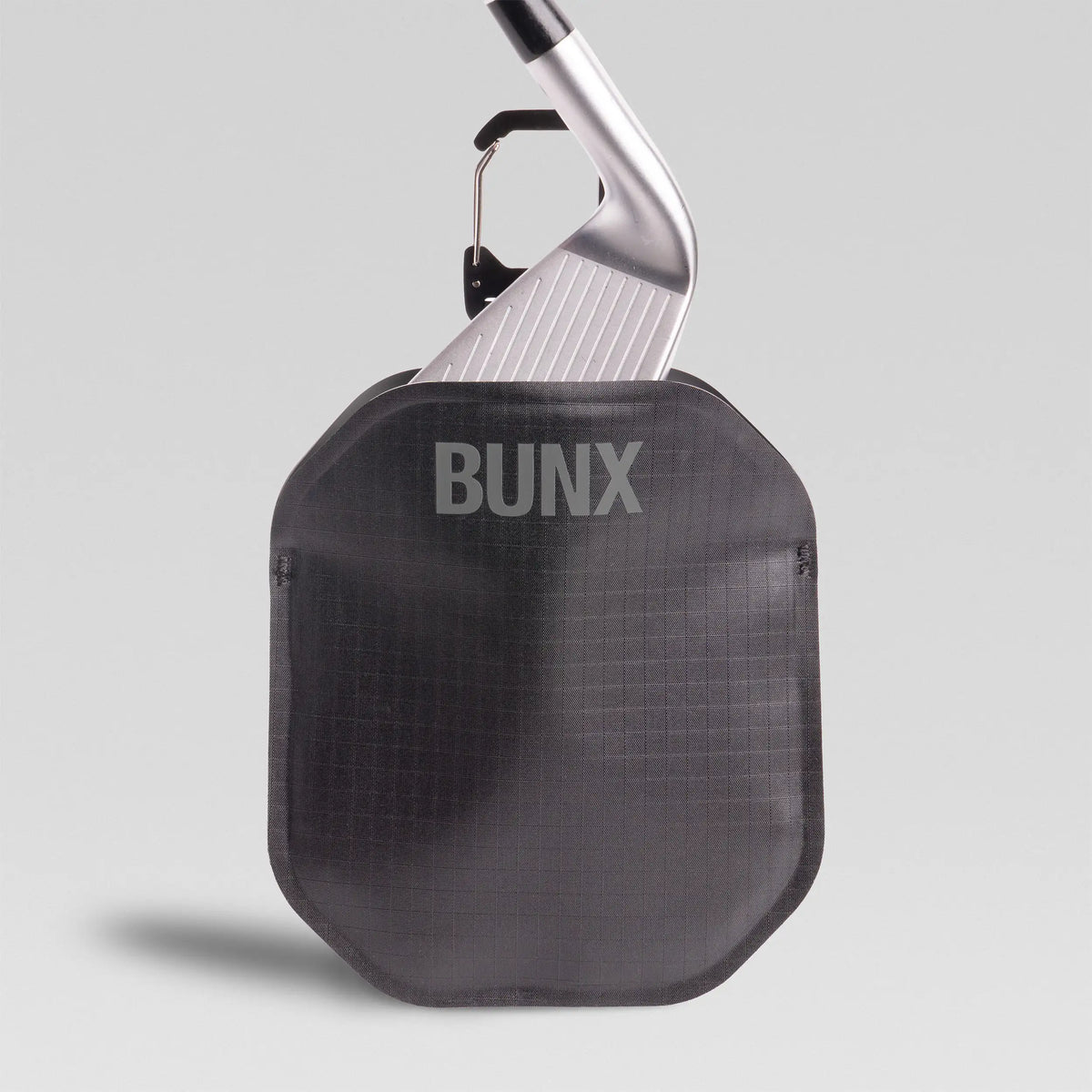 Black BUNX Golf Scrub Pouch with iron clubhead inserted, part of pouch and tee bundle