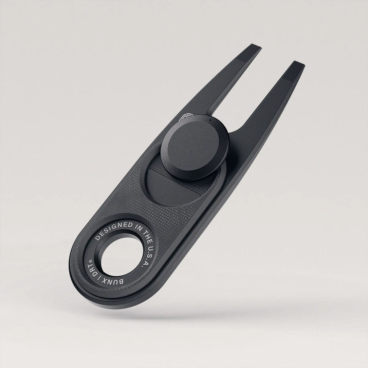 BUNX Golf DRT divot repair tool in black PVD with black ball marker, angled hero view